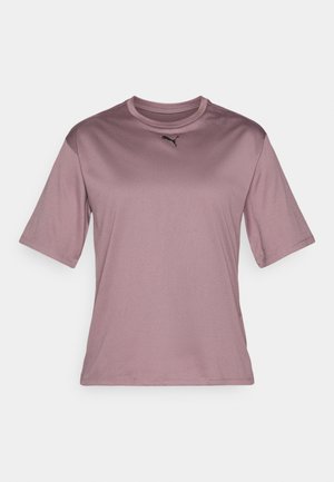 Jasnofioletowa sportowa koszulka z krótkim rękawem, z okrągłym dekoltem i małym czarnym logo Pumy umieszczonym centralnie przy kołnierzu.