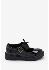 Chaussure Mary Jane en cuir verni noir avec un bout rond, fermeture à boucle et un accent en nœud sur la sangle. Semelle en caoutchouc épaisse avec traction.