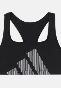Soutien-gorge de sport noir avec un design dos nageur. Présente des rayures blanches horizontales en bas à gauche, contrastant avec le tissu uni.