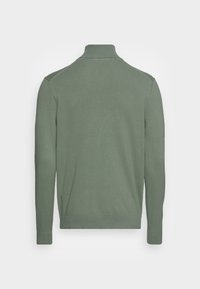 Maglione verde con collo alto, maniche lunghe e polsini a coste. Realizzato in morbido materiale a maglia, con una texture liscia.