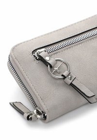 Portefeuille en simili cuir gris clair avec deux fermetures éclair argentées et un anneau métallique circulaire attaché à une lanière en cuir.