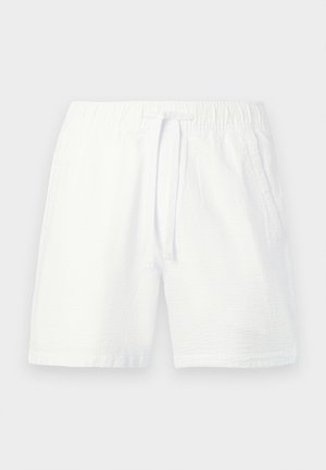 Baltos tekstūruotos medžiagos šortai su elastiniu liemeniu ir raišteliu, šonuose kišenės, paprastame fone.