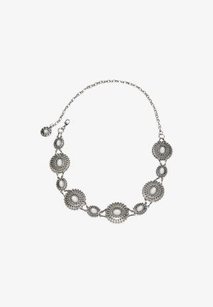 Stříbrný řetízek s oválnými květinovými medailonky propojenými dohromady, každý s bílým středovým kamenem.