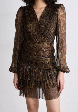 Mujer con un minivestido marrón de manga larga, plisado, con estampado de leopardo y cuerpo cruzado, sobre un fondo liso.