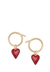Złocone kolczyki w kształcie kół z czerwonymi sercowymi charmsami z ceramiki, oferujące błyszczące wykończenie i gładką teksturę.
