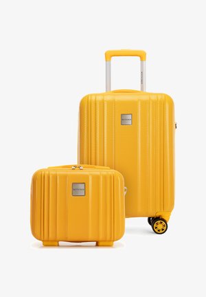Dos maletas rígidas amarillas, una grande con asa telescópica y ruedas, y una pequeña con asa, ambas texturizadas con placas del logo de la marca.