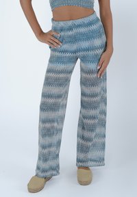 Pantaloni a palazzo blu e beige con motivo a zigzag, realizzati in tessuto strutturato, dotati di vita elastica e vestibilità comoda.