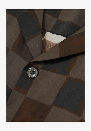 Bruin en zwart geblokt stof met een gestructureerde afwerking, waarbij een opvallende ronde grijze knop op de kraag is geplaatst.