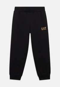 Pantalones deportivos negros con cinturilla elástica, puños ajustados y un pequeño logo dorado "EA7" en el bolsillo derecho. Hechos de tela suave.