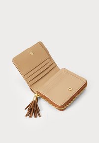 Portafoglio in pelle beige aperto che mostra diversi scomparti per carte, una tasca con zip per monete con cerniera dorata e un tassello come tirante su uno sfondo bianco.