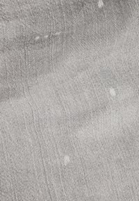 Harmaan kuvioitu kangas, jossa on herringbone-kudonta, hienovaraisia valkoisia pilkkuja ja sileä, tekstuuriltaan miellyttävä pinta.