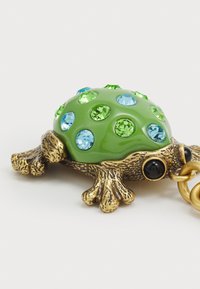 Green frog-shaped keychain with a glossy body, embellished with blue and green rhinestones, and a gold-tone metal base and chain.