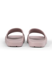 Rosa slip-on sandaler gjorda av flexibelt material, med platta sulor och två böjda remmar för fotstöd, med en texturerad yta.
