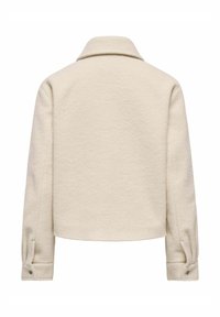 Veste en laine beige avec un col, un design court et des poignets boutonnés. Texture douce et coutures invisibles à l'arrière.