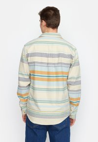 Heren overhemd met lange mouwen in crème met horizontale strepen in blauw, groen, geel en paars. Voorzien van een kraag en knoopmanchetten.