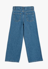 Vaqueros de mezclilla azul de pierna ancha con cintura alta, que cuentan con dos bolsillos traseros y un acabado limpio en el dobladillo. Tela de algodón con un aspecto texturizado.
