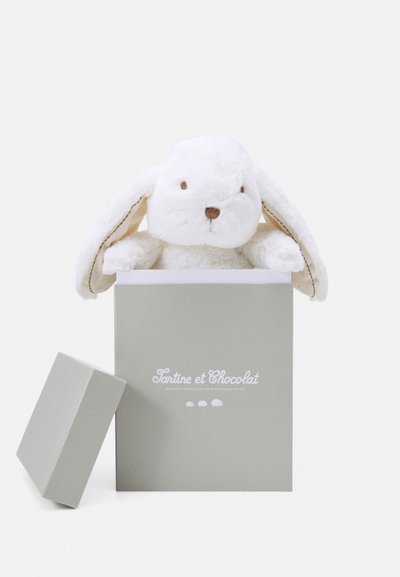 Un lapin en peluche émergeant d'une boîte cadeau gris clair, avec un doux pelage blanc, de longues oreilles tombantes et un visage brodé simple.
