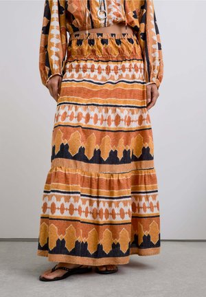 Falda maxi en patrones naranja, marrón y negro. Hecha de una tela ligera, cuenta con una cinturilla elástica y un diseño de volantes en capas.
