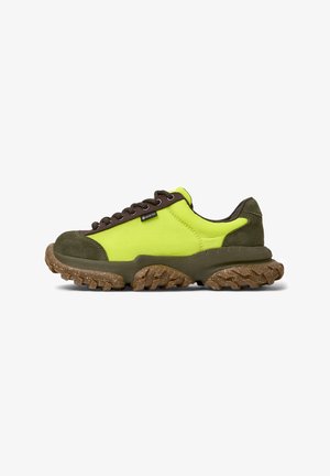 Zapatilla de color verde lima y marrón con una suela gruesa y texturizada y cordones, que presenta una etiqueta Gore-Tex en el lateral.