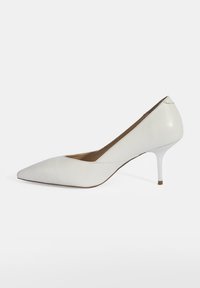 Weißer Leder-High-Heel-Schuh mit spitz zulaufender Zehenpartie und dünnem Stiletto-Absatz. Glatte Textur und minimalistisches Design mit klaren Linien.