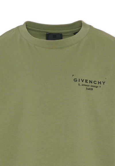 T-shirt à col rond vert olive avec texte noir "GIVENCHY 3, Avenue George V PARIS" imprimé sur la partie gauche de la poitrine.
