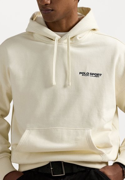 Kremfarget hettegenser laget av bomull, med en lommer foran og snor i hetten. Svart "POLO SPORT" logo på brystet. Enkel design.