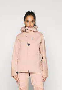 Casaco impermeável rosa claro com gola alta, capuz ajustável e detalhes em preto. Apresenta um design elegante e múltiplos fechos éclair.