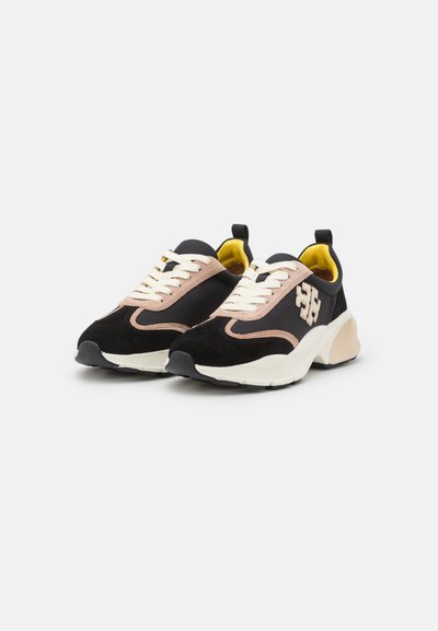 Svarta och rosa sneakers med en överdel i mocka och textil, snörning, vadderad krage och en kraftig vit mellansula. Accentlogotyp synlig.