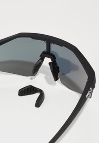 Schwarze Sportsonnenbrille mit großen getönten Gläsern, gummierten Nasenpads und verstellbaren Seitengriffen. Robuster Rahmen mit Logodetail.