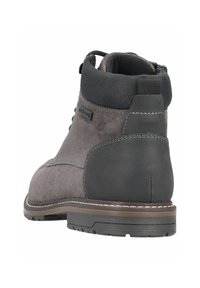 Stivale alla caviglia in suede grigio con tacco in pelle, bordo imbottito nero a contrasto e design con lacci. Presenta dettagli di cucitura e una suola testurizzata.