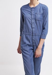 Jeansjumpers med rund halsringning, trekvartslånga ärmar och en framficka. Ljusblå färg och midjeband för en tight passform.