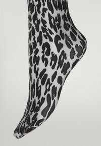 Sorte og hvide leopardmønstret sok, der har en glat tekstur og en tætsiddende form, skåret omkring anklen med et tilspidset tådesign.