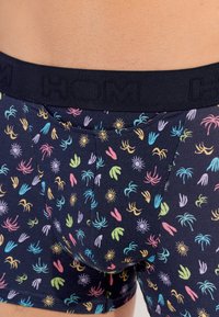 Boxer in tessuto blu navy scuro con un motivo ripetuto di foglie di palma colorate e soli. Vita elastica nera con logo "HOM".