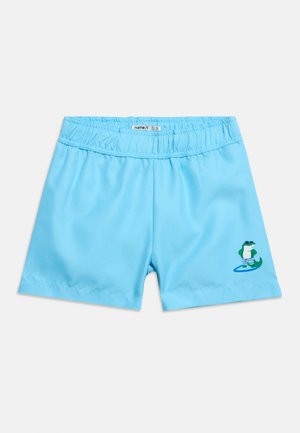 Pantaloncini da nuoto per bambini di un brillante colore blu con una fascia elastica in vita e un piccolo coccodrillo cartoon che indossa pantaloncini da bagno e occhiali da sole sulla gamba.