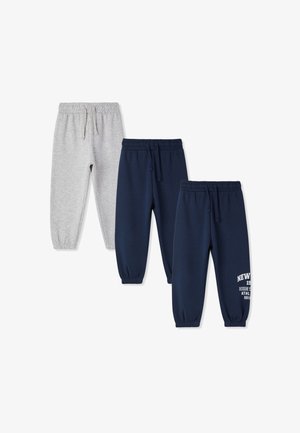 Trzy pary spodni dresowych dla dzieci: jedna szara, dwie granatowe, z elastycznymi paskami w talii i ściągaczami, z nadrukiem na ciemniejszych spodniach.