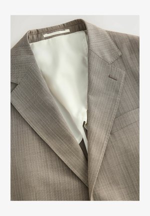 Kerge pruun triibuline bleiser sileda beeži voodriga. Omab klapiga krae ja rinna taskut. Materjal näib tekstuurne ja vastupidav.