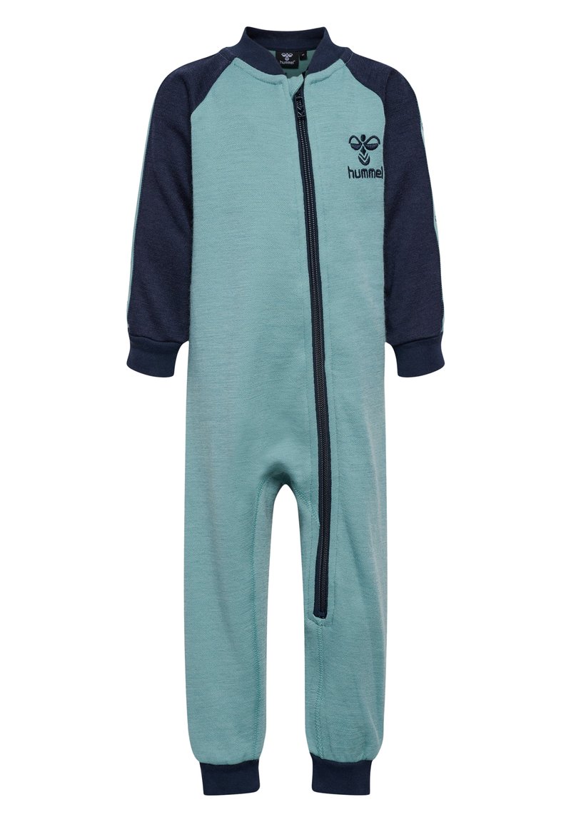 Ljusblå jumpsuit med marinblå lång ärm, full dragkedja framtill, ribbade muddar och logotypdetalj på bröstet. Mjuk textur, rak bendesign.