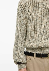 Pull en maille tons beiges avec un motif texturé ; doté d'un ourlet large côtelé et de manches surdimensionnées. Associé à une ceinture noire.