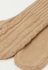 Beige Kabelstrickhandschuhe mit gerippten und strukturierten Mustern, aus weichem Garn gefertigt, mit abgerundetem Rand am Handgelenk.