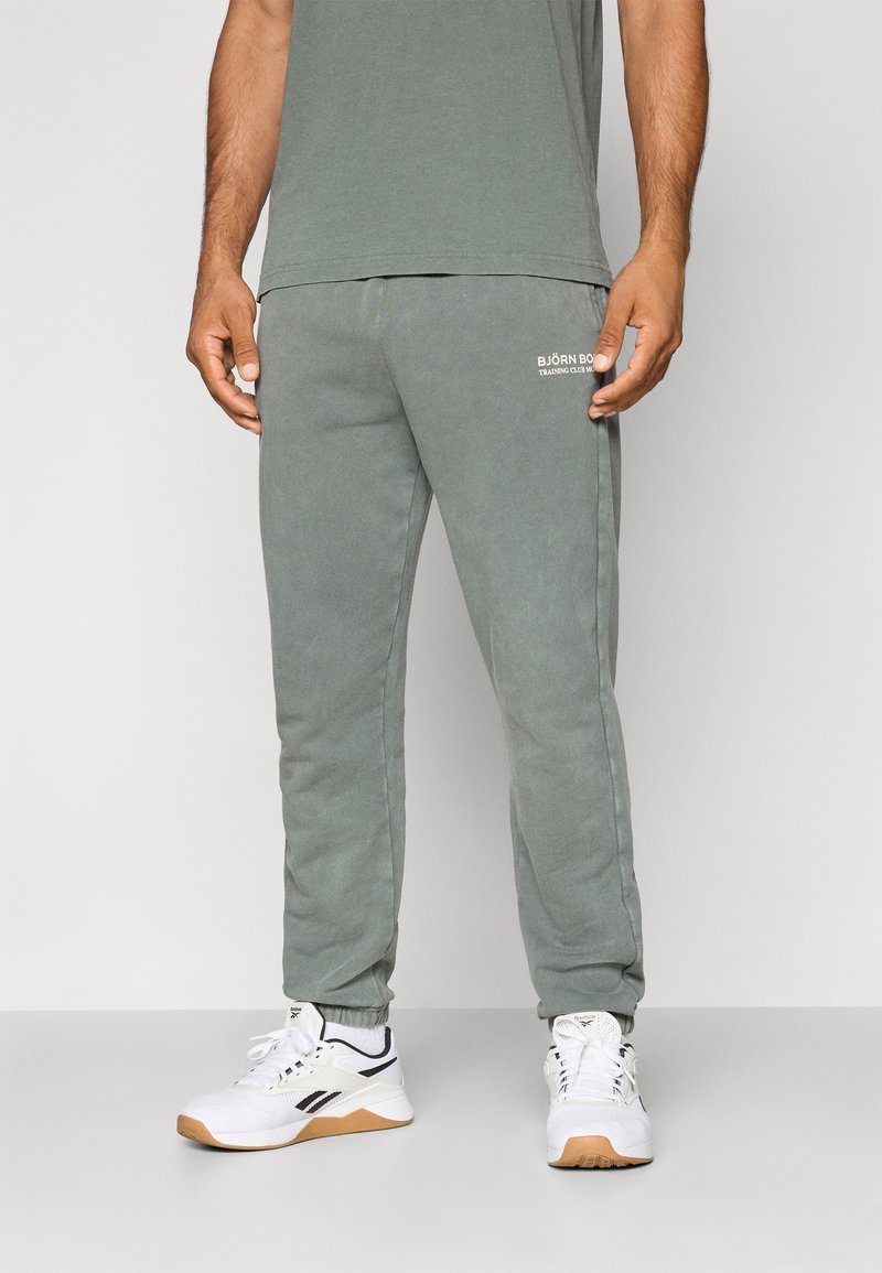 Ανοιχτό γκρι φόρμα με απαλή υφή, διαθέτει ελαστική μέση και κατάλληλους μανσέτες. Μικρό λευκό λογότυπο στο αριστερό μηρό.