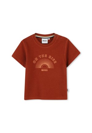 Rooienkleurig T-shirt met korte mouwen en ronde hals, met voorop de tekst "ON THE RISE" en een zonafbeelding. Drukknoopjes op de schouder.