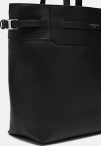 Czarna skórzana torba na ramię o gładkiej fakturze, minimalistycznym designie, podwójnych uchwytach, srebrnymi detalami oraz zapięciu na klapę.