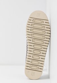 Suola della scarpa in gomma beige chiaro con motivo di grip texture, con logo centrale e indicazione della taglia (37) impressa vicino alla punta.