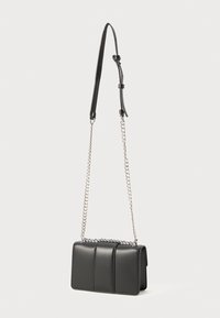 Black leather bag with quilted design, featuring a silver chain and leather strap. Compact, rectangular shape with a flap closure.