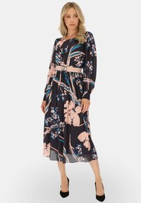 Kwiatowa sukienka midi w granatowym kolorze, z różowymi i niebieskimi wzorami, długimi rękawami, elastycznym stanem oraz białym paskiem z okrągłą klamrą.