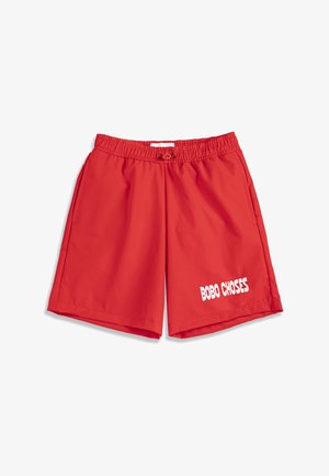 Shorts rouges à taille élastique avec cordon de serrage et poches latérales, arborant le texte blanc « BOBO CHOSES » sur la partie inférieure de la jambe droite.