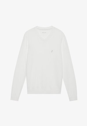 Bílý svetr s V výstřihem z měkké látky, s dlouhými rukávy a malým vyšitým logem na levé hrudi. Hladká textura, klasický design.