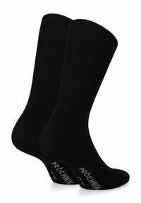 Czarne bawełniane skarpetki z żebrowanym mankietem, bezszwowym palcem i wzmocnioną piętą; posiadają białe logo na podeszwie.