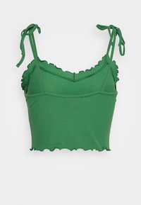 Crop top vert côtelé avec des bords festonnés et des bretelles à nouer réglables. Fabriqué en tissu extensible pour un look ajusté.