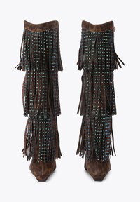Stivali alti fino al ginocchio in suede marrone con frange a strati, adornati con borchie blu e rosse, caratterizzati da una punta affilata e un tacco basso.